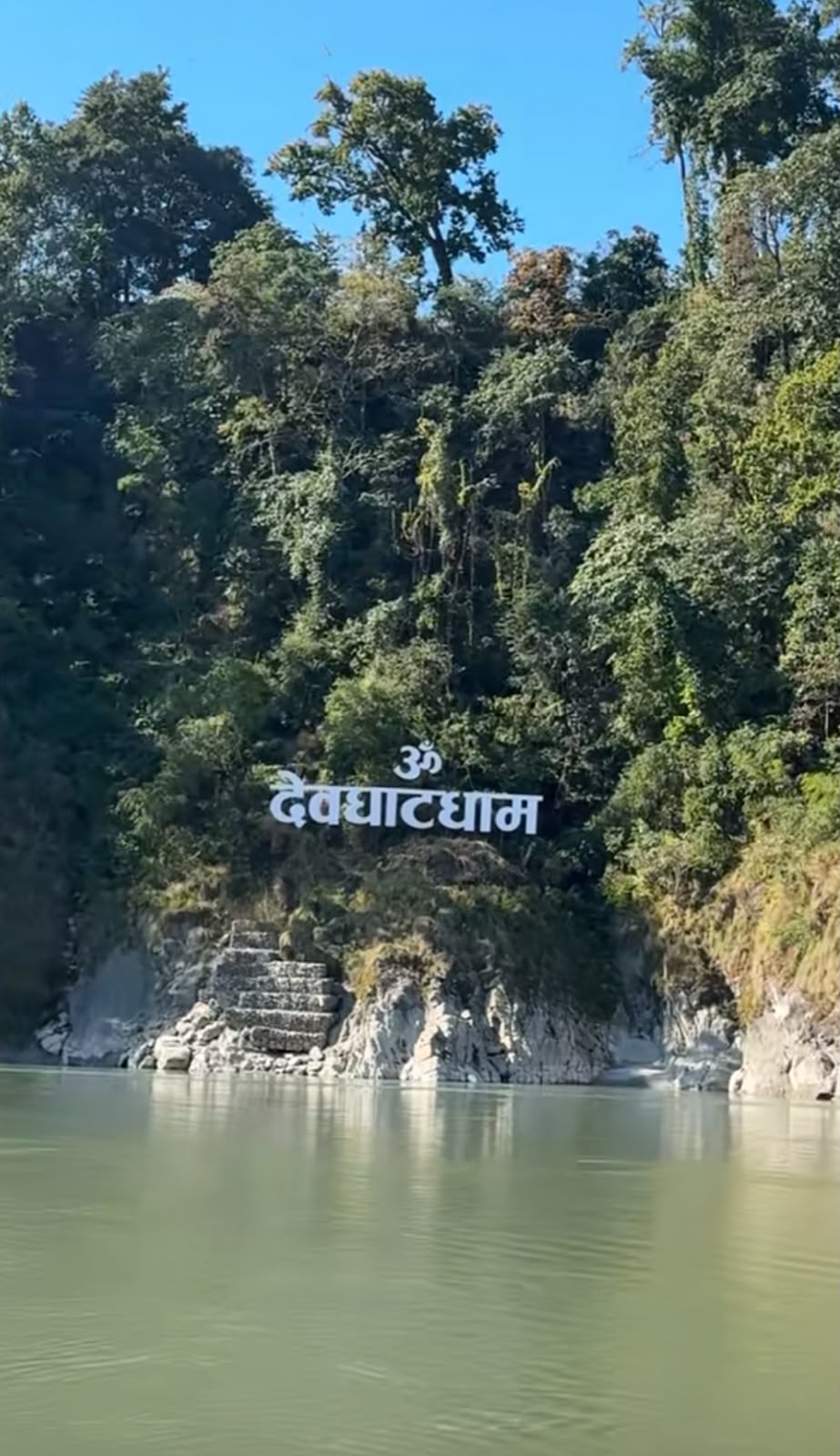 Pilgrims performing rituals at Devghat's sacred river confluence
